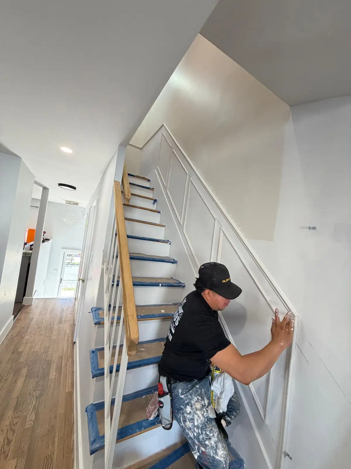 Carpenter installing staircase wall trim — Bath Beach, Brooklyn