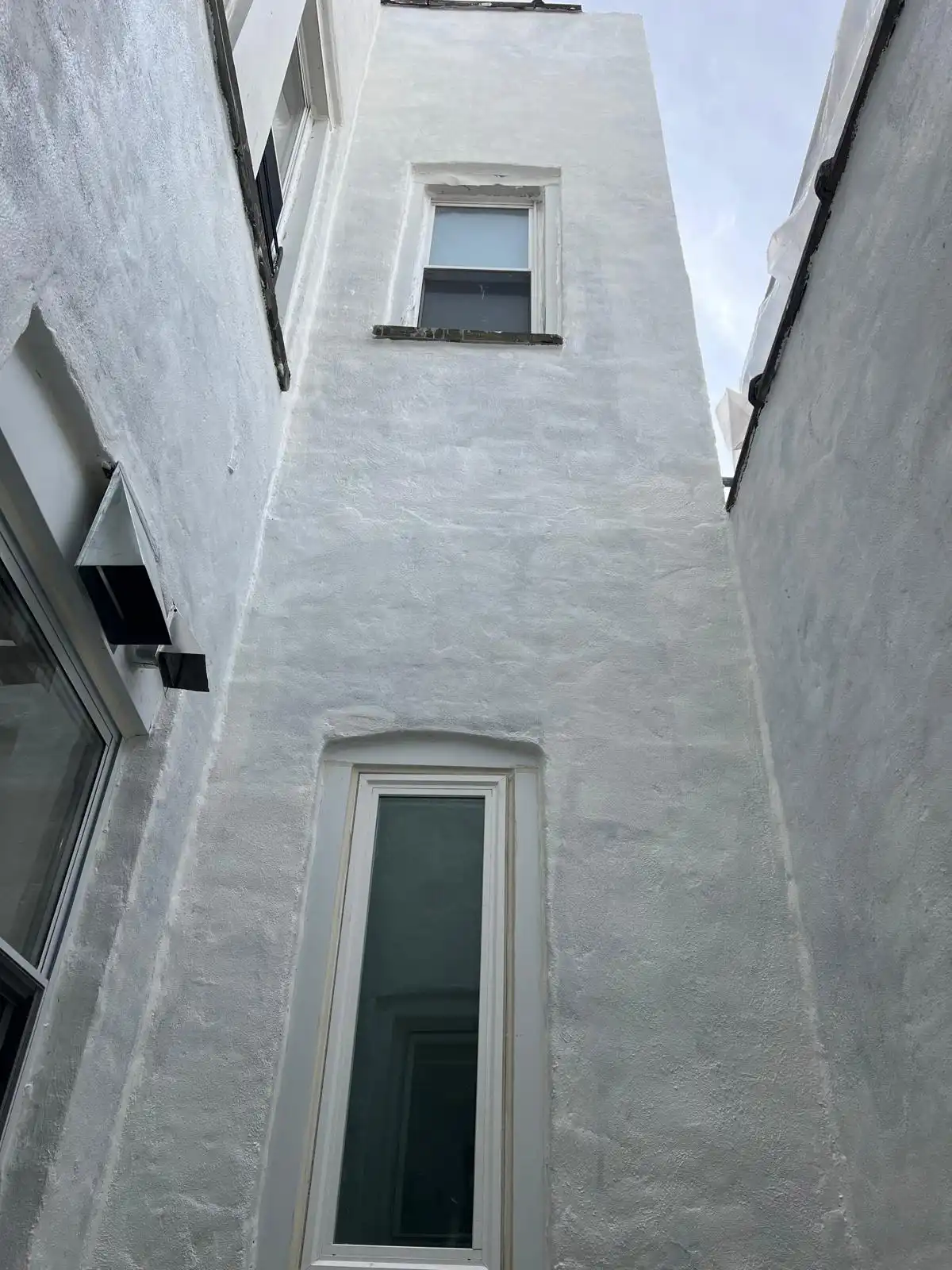 Coated exterior wall with new window — East New York, Brooklyn