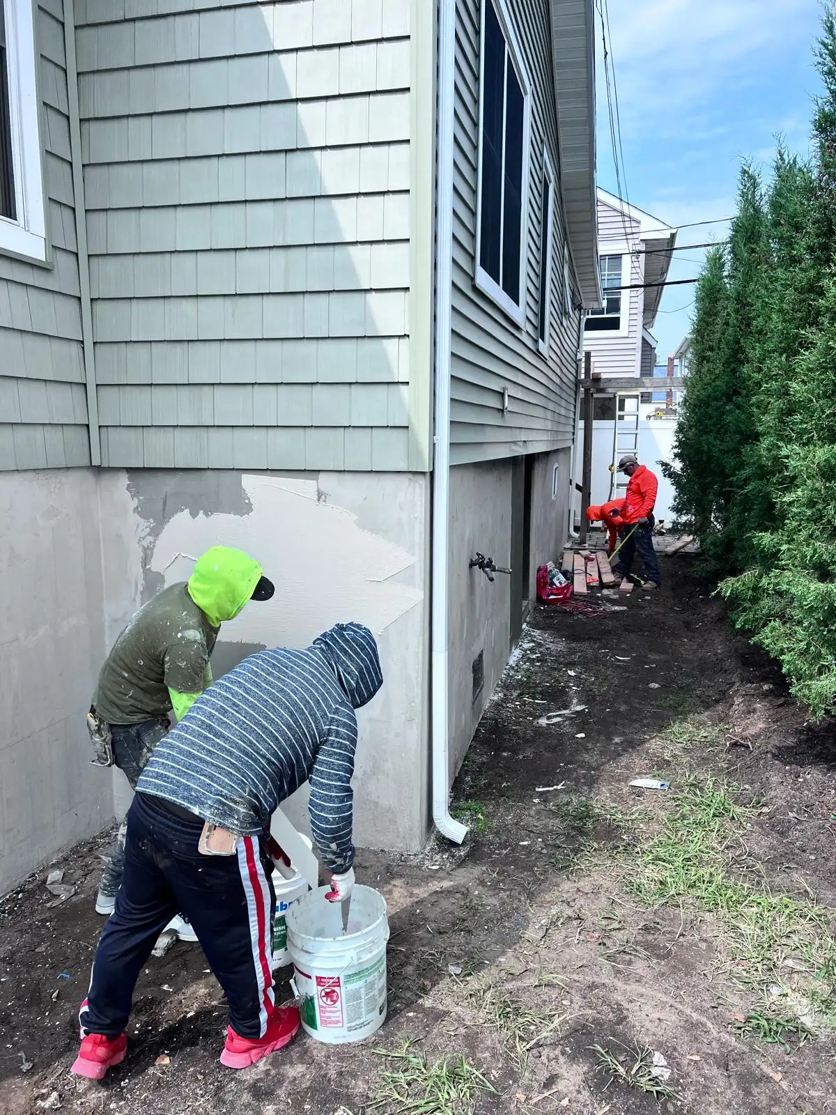 Crew applying stucco base coat — East Meadow, Long Island