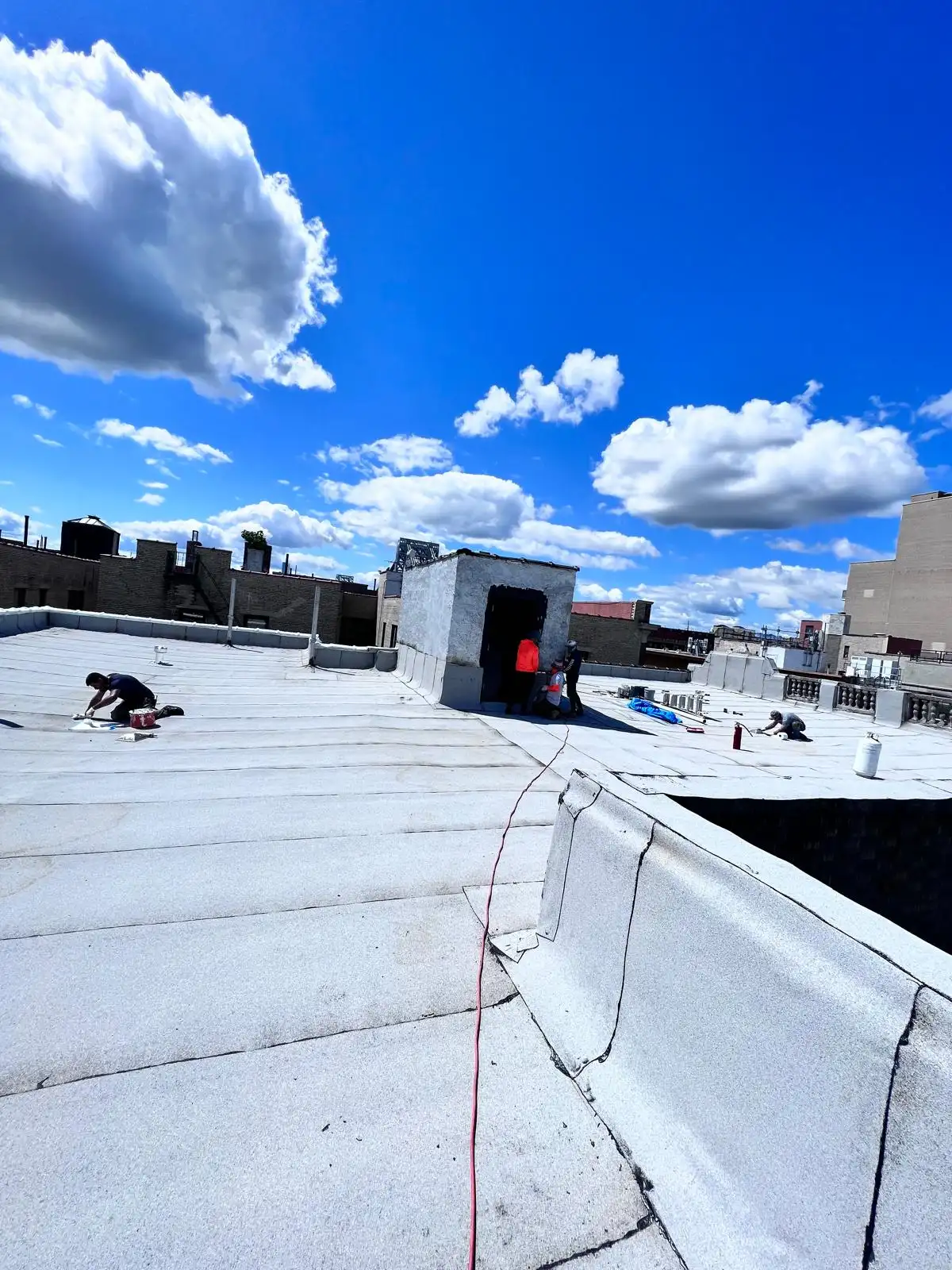 Crew at work on roof edge — Washington Heights, Manhattan