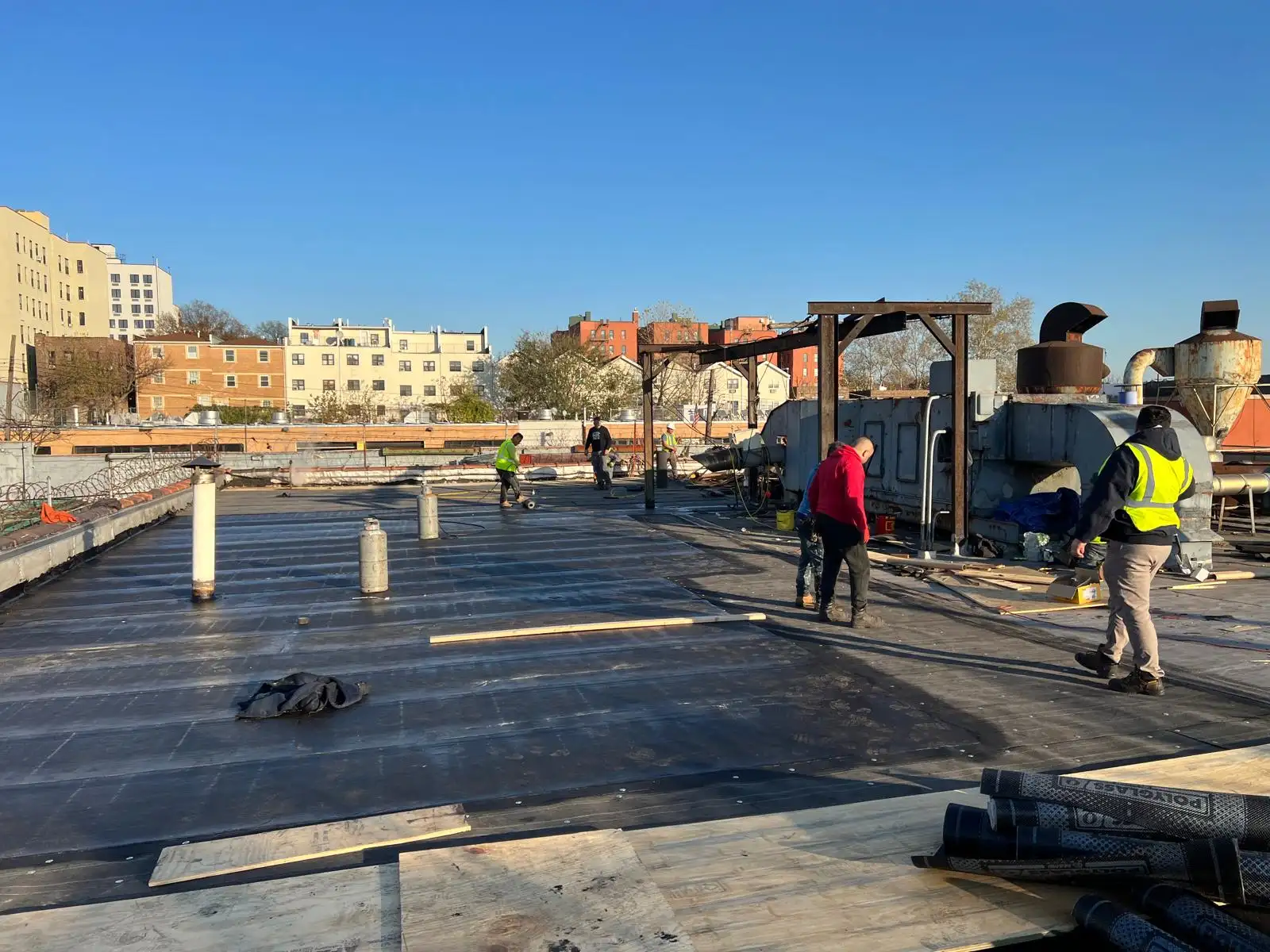 Crew finishing roof seams — Hunts Point, Bronx
