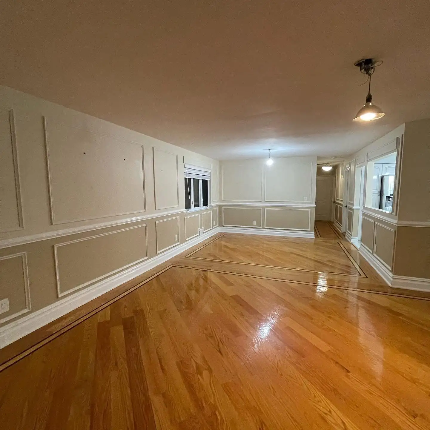 Open living area with wall molding and glossy hardwood floor — Arrochar, Staten Island