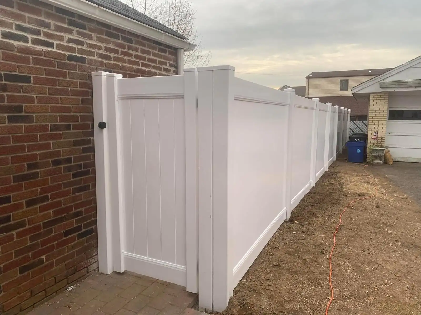 PVC fence with gate next to brick house — Arrochar, Staten Island