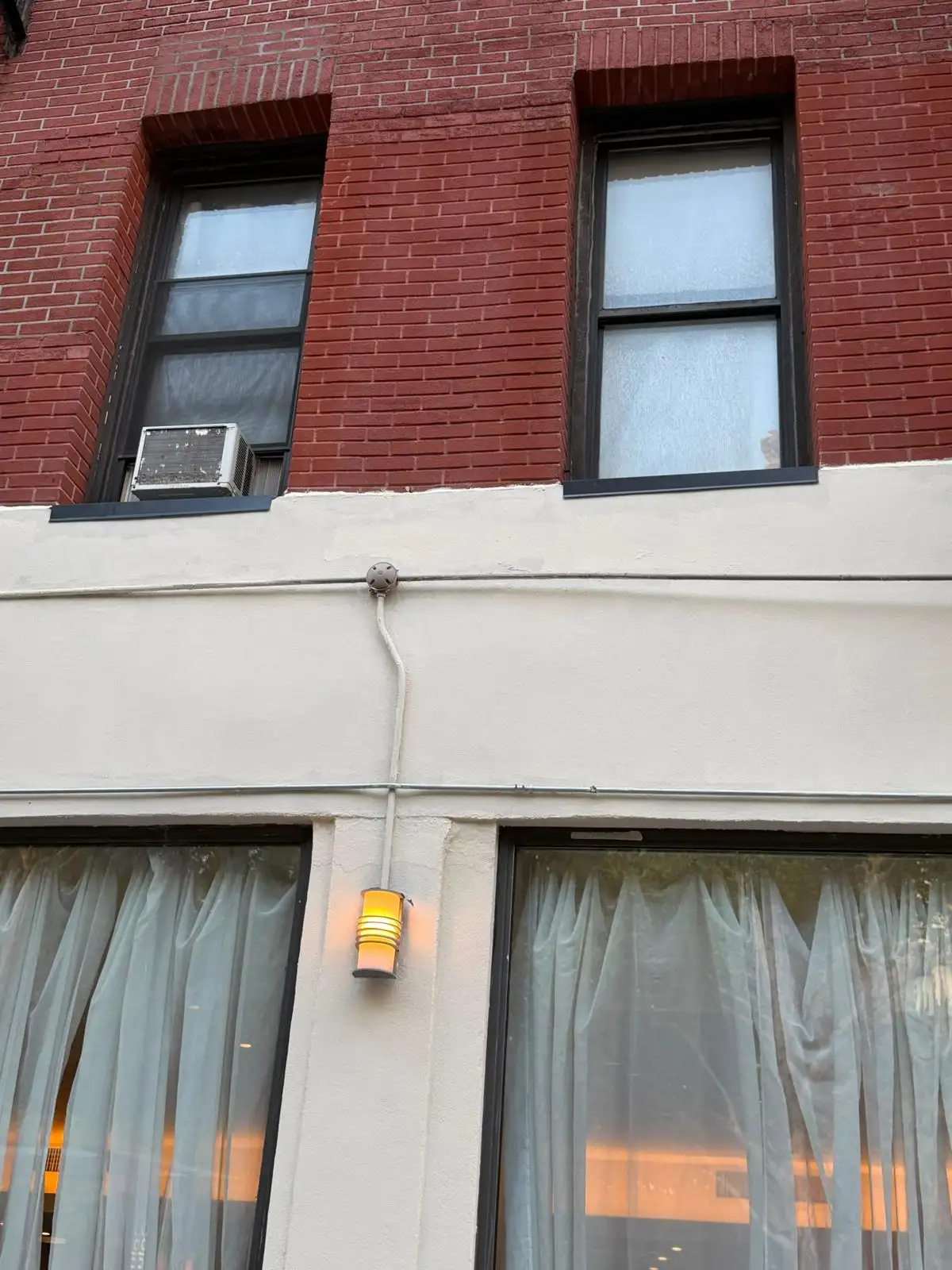 Repaired and painted stucco below brick facade — Upper West Side, Manhattan