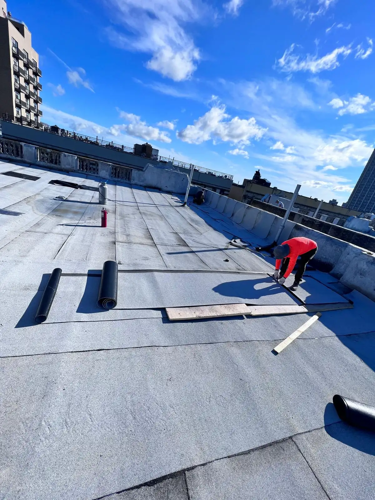 Roofer installing cap sheet — Washington Heights, Manhattan