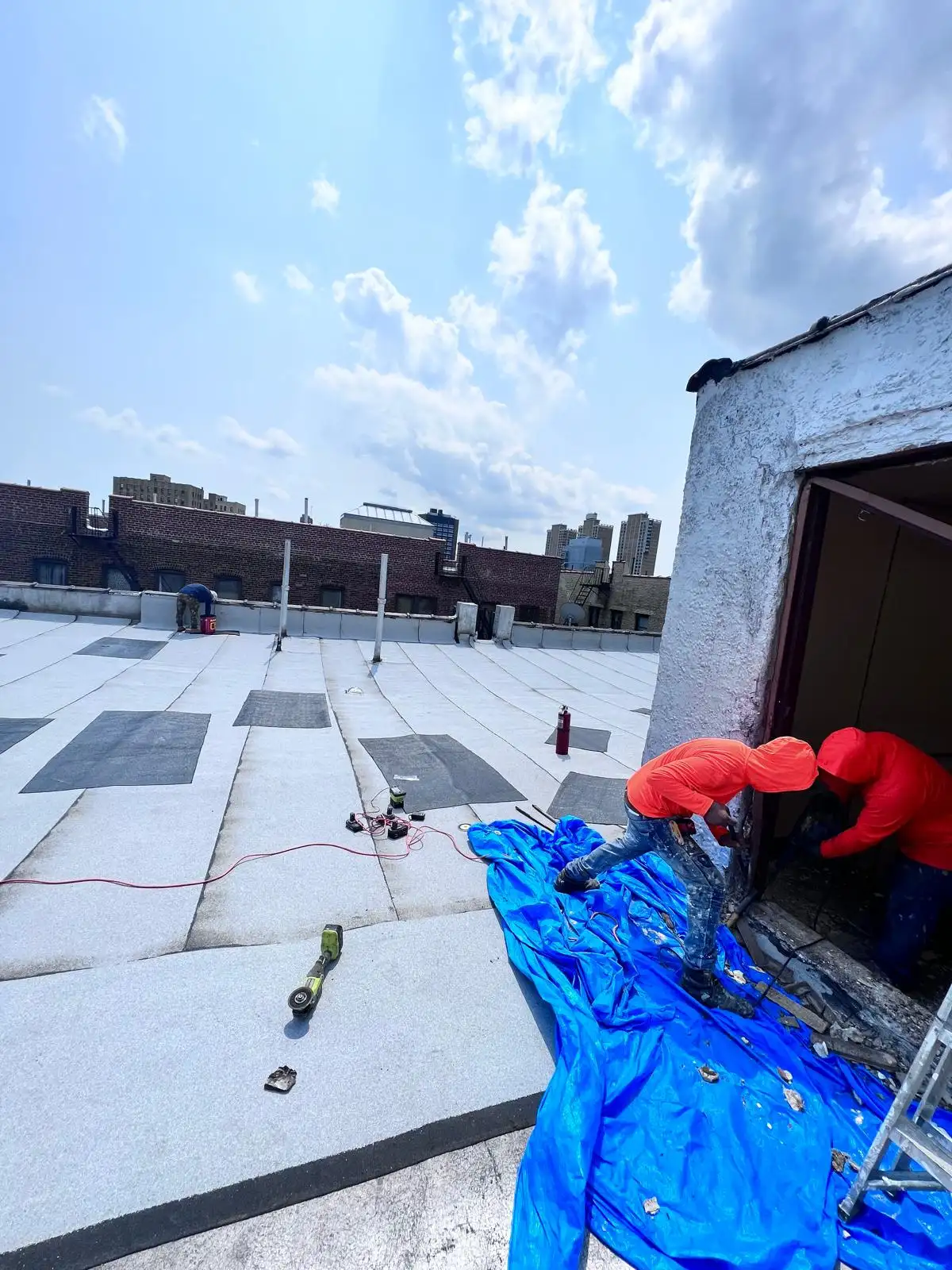 Roofer sealing bulkhead door frame — Washington Heights, Manhattan