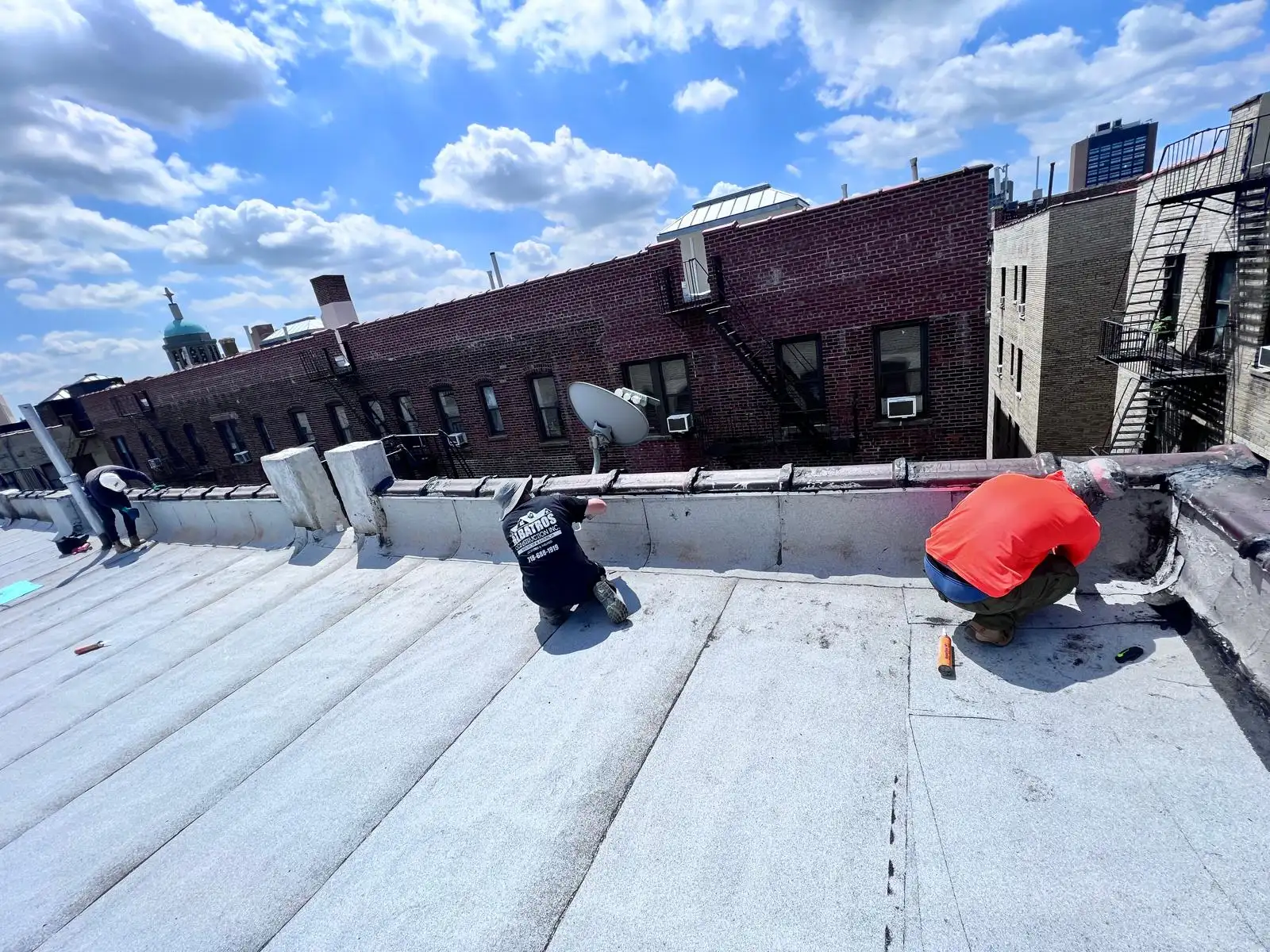 Roofers finishing roof edge — Washington Heights, Manhattan