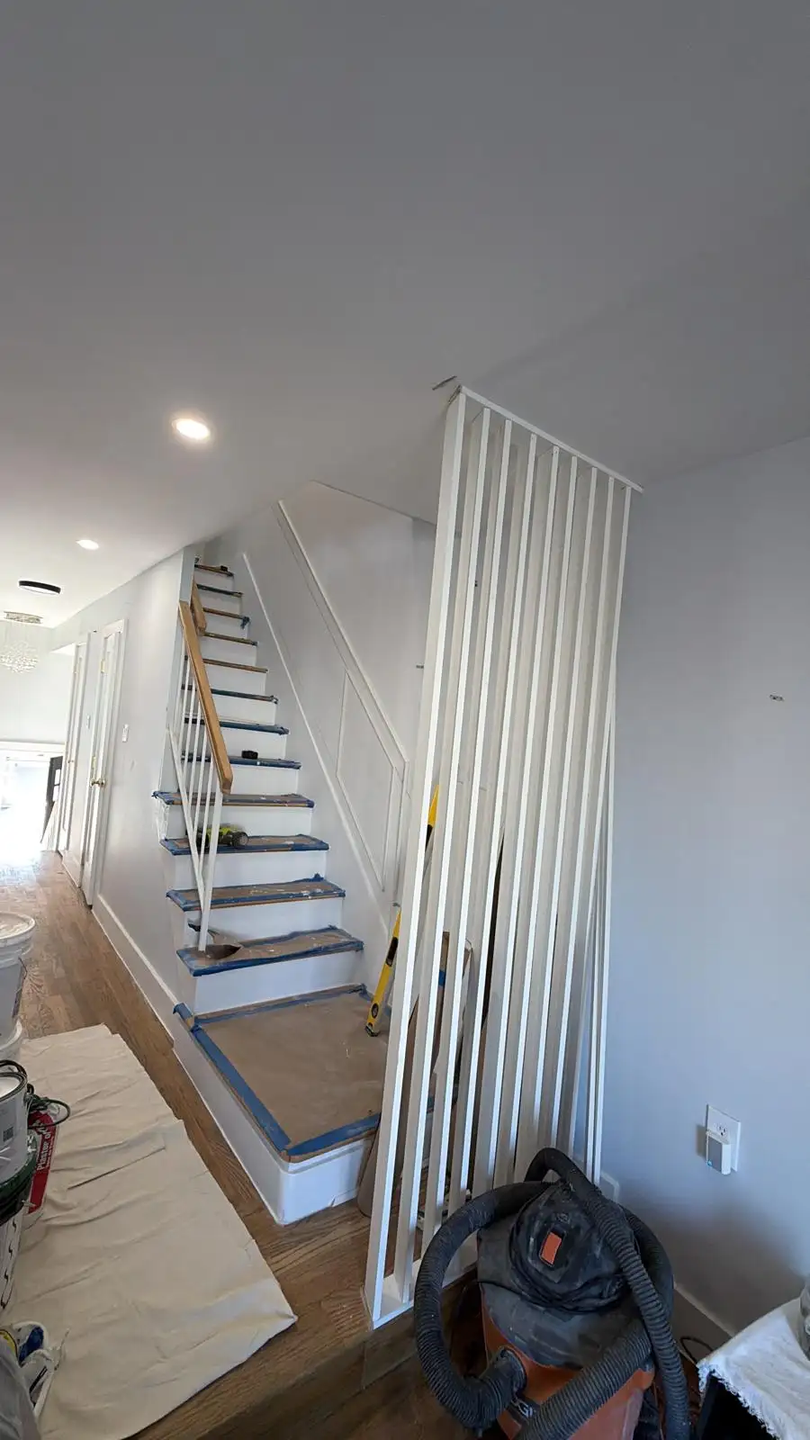 Vertical slat wood accent wall by staircase — Bath Beach, Brooklyn